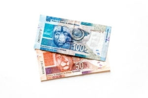 A one hundred ZAR note laying on top of a fifty Rand note