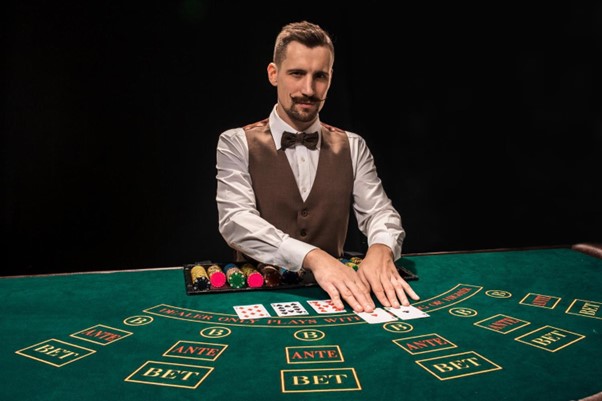 White male dealer at casino table with waistcoat and bowtie