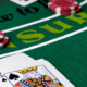 Ace and King of spades with casino chips on Blackjack table